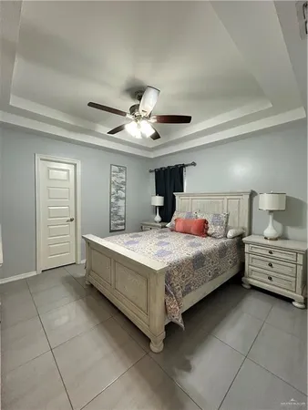 a bedroom with a large bed and ceiling fan