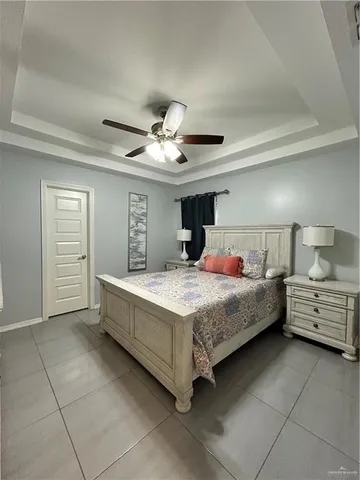 a bedroom with a large bed and ceiling fan