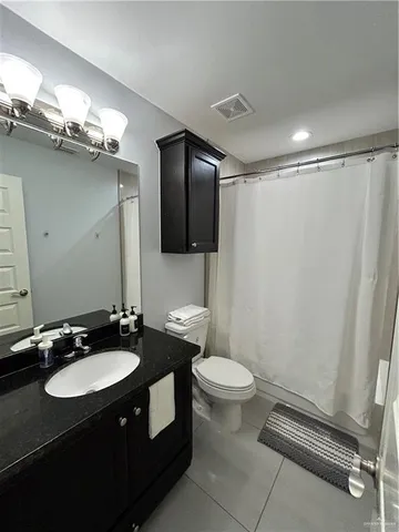 a bathroom with a sink a toilet a mirror and shower
