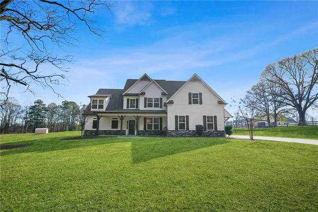 a view of a white house with a big yard and potted plants