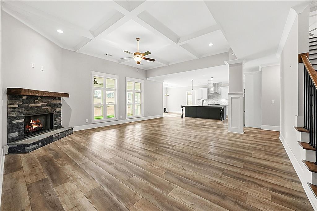 2519 Hog Liver Road Carrollton, GA 30117 - Photo 12 of 39 an empty room with wooden floor fireplace and windows