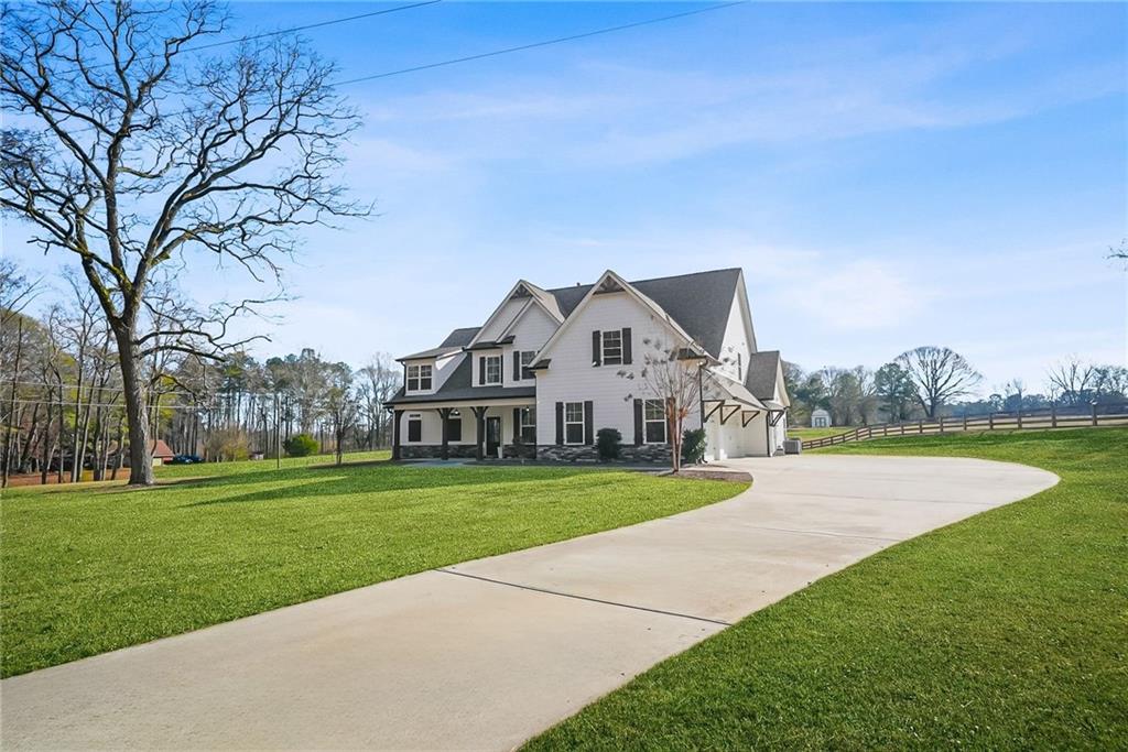 2519 Hog Liver Road Carrollton, GA 30117 - Photo 2 of 39 a view of a white house with a big yard and potted plants