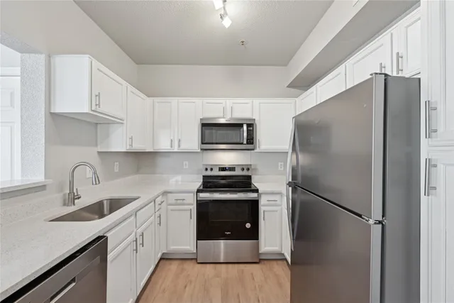 a kitchen with stainless steel appliances a refrigerator stove and sink