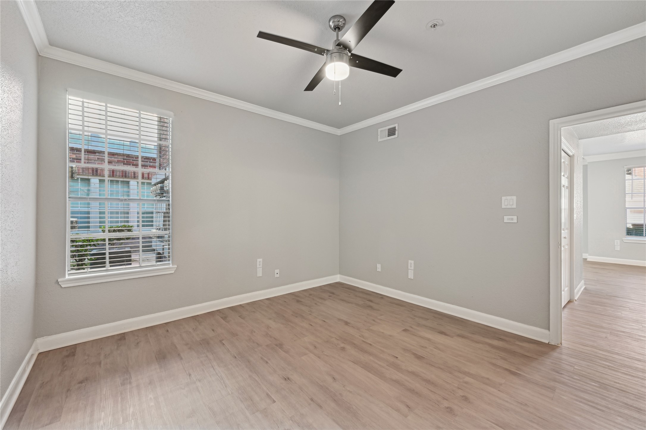 10990 West Road, Unit 203 Houston, TX 77064 - Photo 21 of 23 an empty room with wooden floor ceiling fan and windows