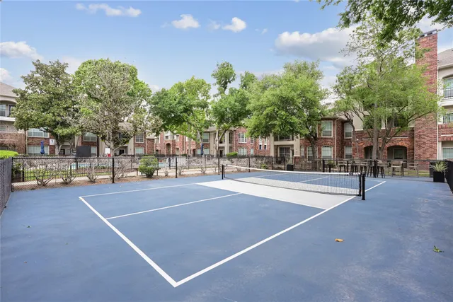 a view of a tennis court with trees in the background