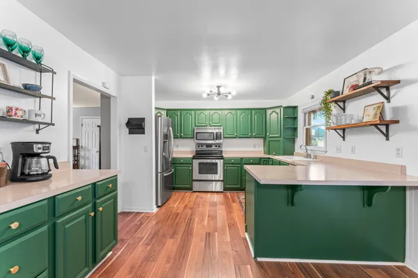 a kitchen with green cabinets a sink and appliances