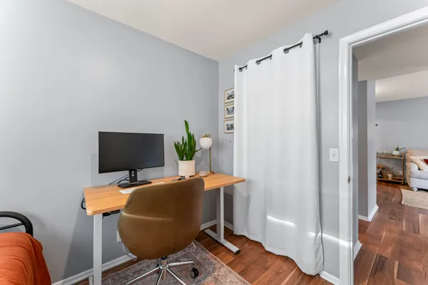 a view of a workspace with furniture and wooden floor