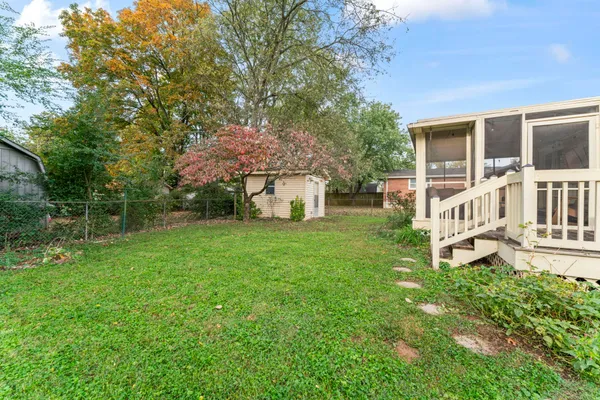 a view of a house with backyard and a tree
