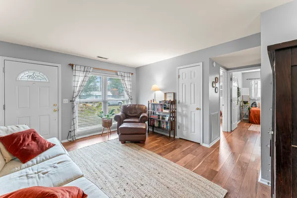 a living room with furniture and a wooden floor