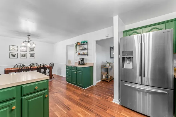 a kitchen with stainless steel appliances a refrigerator and a wooden floor