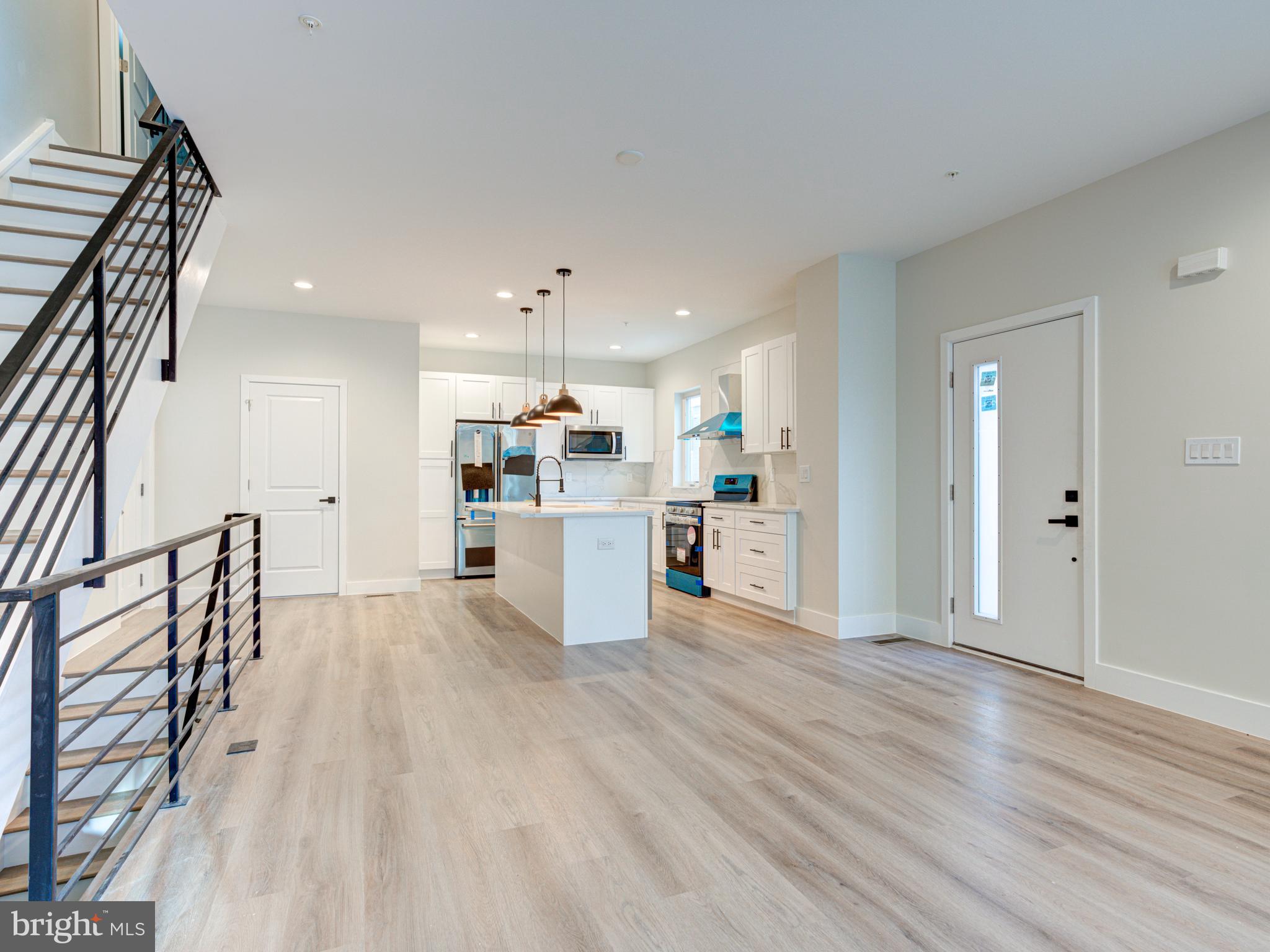 630 Moyer Street Philadelphia, PA 19125 - Photo 32 of 41 a kitchen with stainless steel appliances kitchen island wooden floors refrigerator and white cabinets