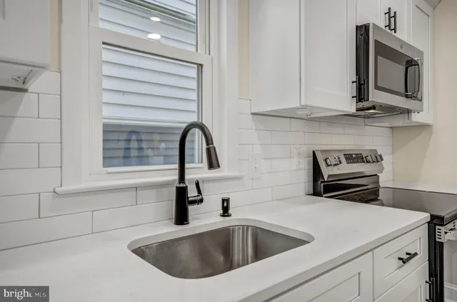 a kitchen with stainless steel appliances granite countertop a sink and a microwave