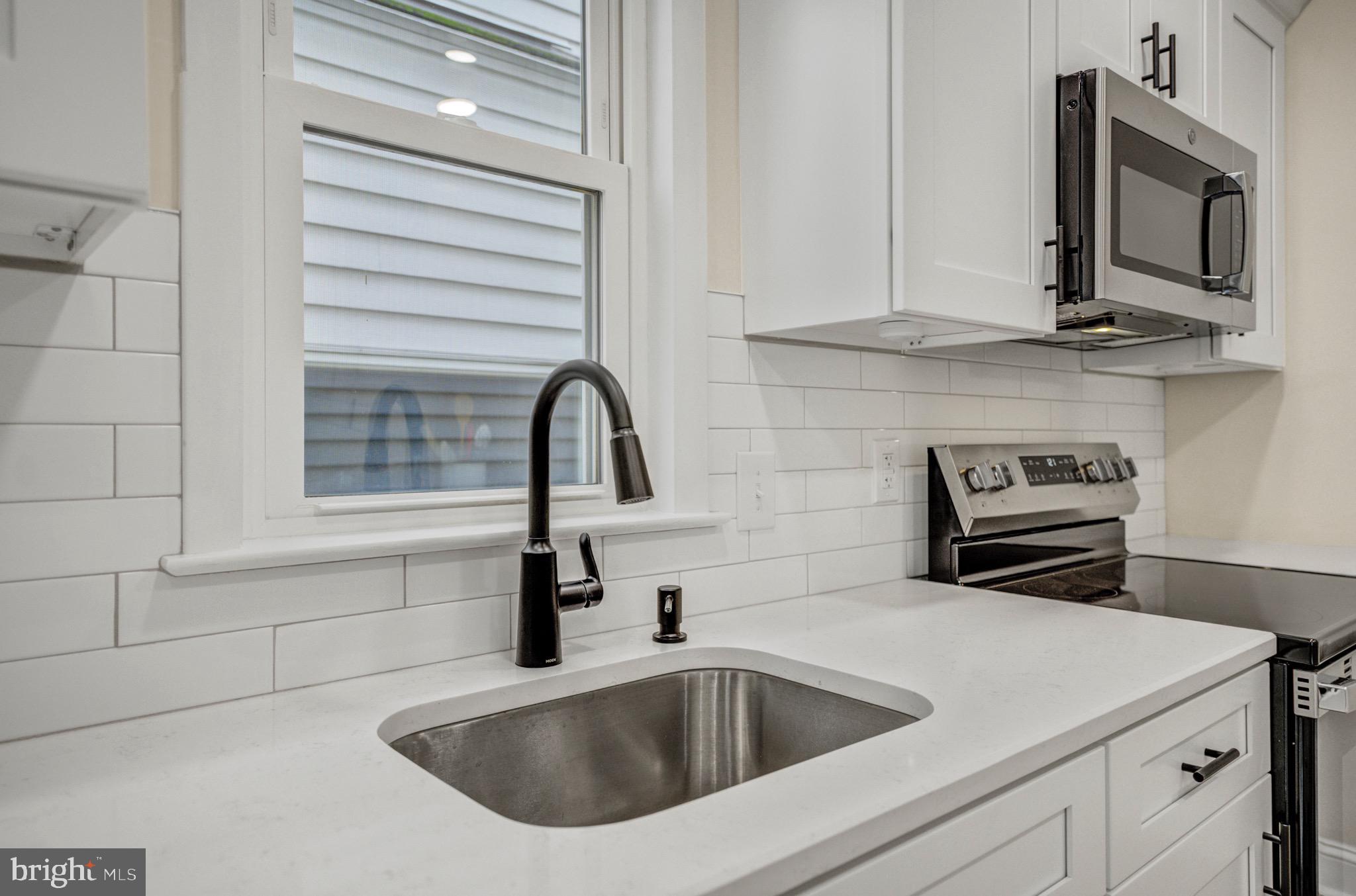 207 Jackson Street Trenton, NJ 08611 - Photo 14 of 37 a kitchen with stainless steel appliances granite countertop a sink and a microwave
