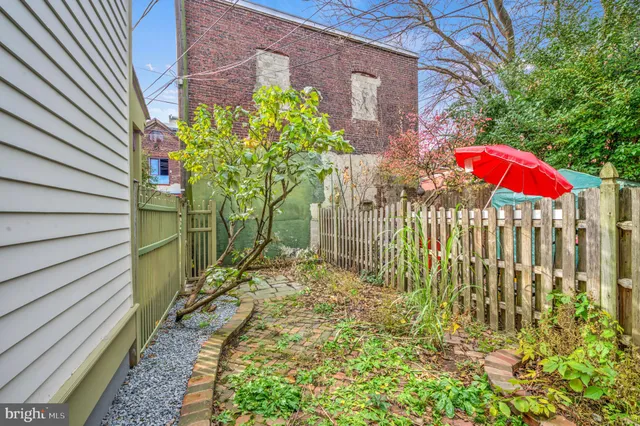 a view of a house with a small yard and wooden fence