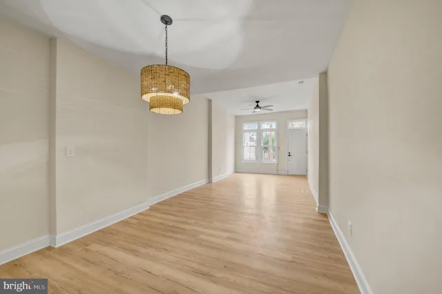 a view of an empty room with window and wooden floor