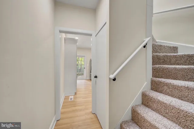 a view of a hallway with wooden floor and entryway