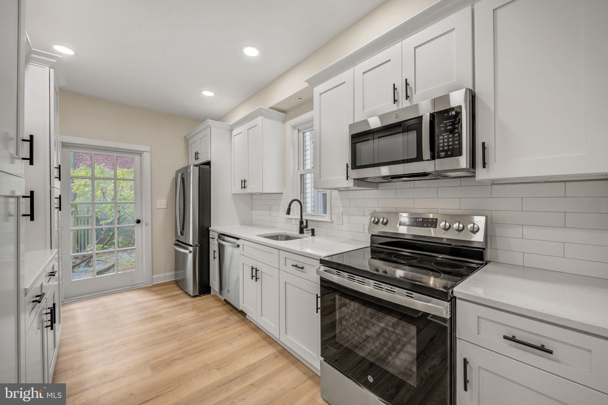 207 Jackson Street Trenton, NJ 08611 - Photo 10 of 37 a kitchen with stainless steel appliances a stove sink microwave and cabinets