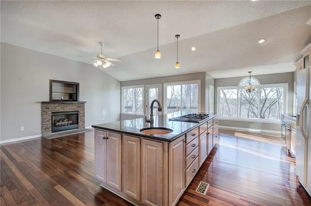 a kitchen with stainless steel appliances granite countertop a refrigerator and a stove top oven