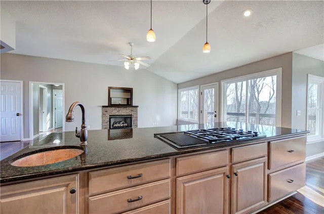 a kitchen with stainless steel appliances kitchen island granite countertop a stove and a sink