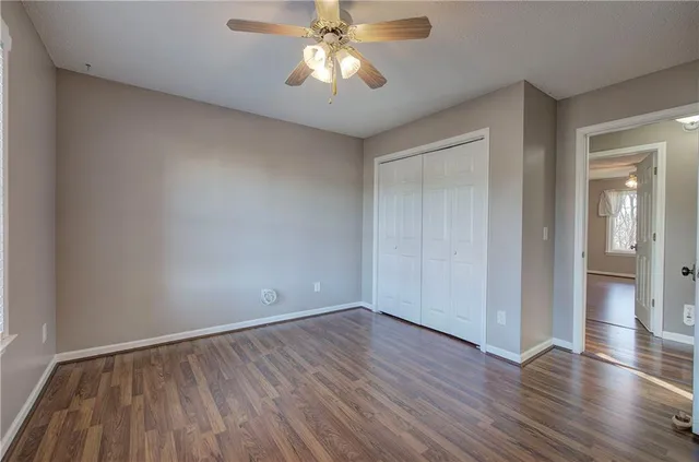 a view of an empty room with a kitchen and window
