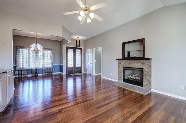 a view of empty room with wooden floor and floor to ceiling window