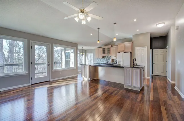 a kitchen with granite countertop a sink cabinets and wooden floor