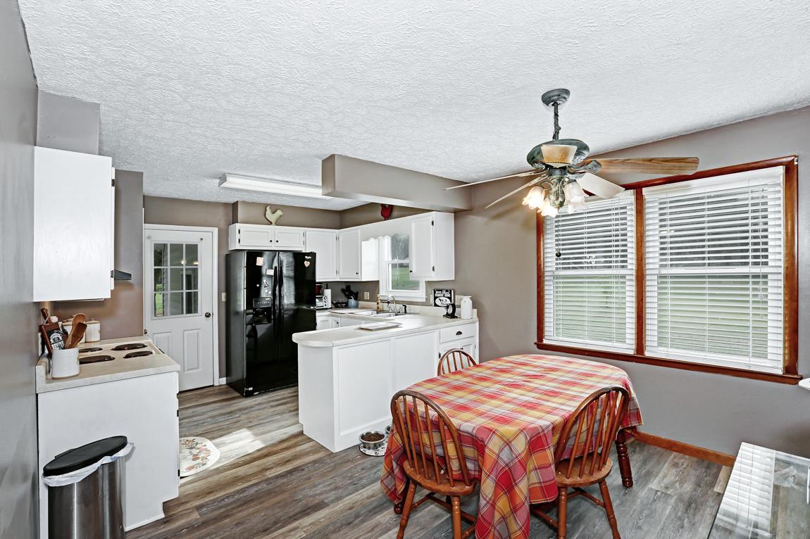 954 Veto Road Prospect, TN 38477 - Photo 9 of 23 a kitchen with a table chairs refrigerator and microwave