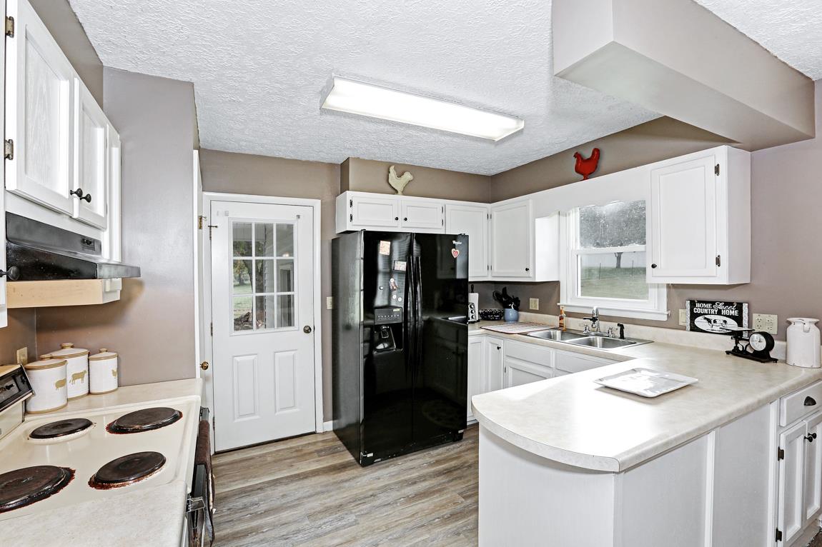 954 Veto Road Prospect, TN 38477 - Photo 10 of 23 a kitchen with a sink a refrigerator and cabinets