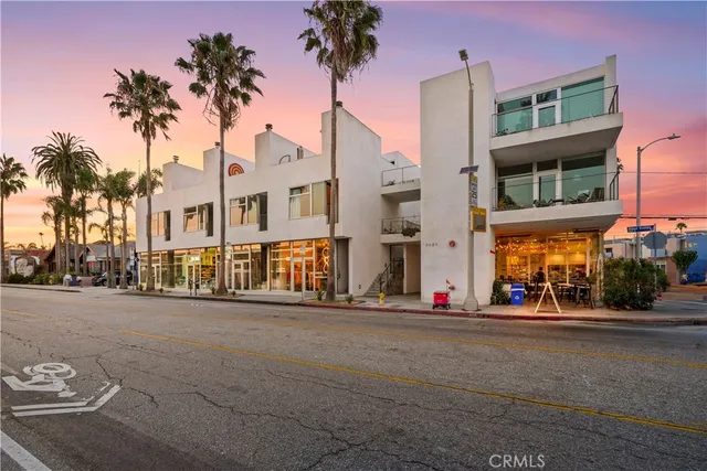 a front view of a building with palm trees