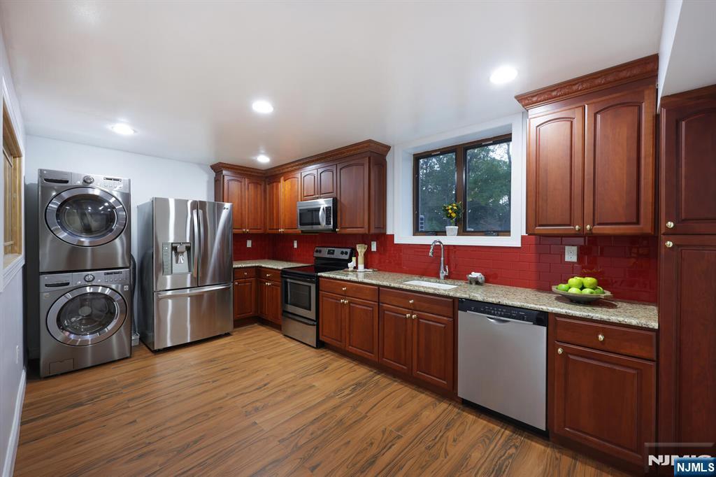 91 Chestnut Ridge Road Saddle River, NJ 07458 - Photo 17 of 50 a kitchen with stainless steel appliances granite countertop a refrigerator a sink dishwasher stove and wooden cabinets