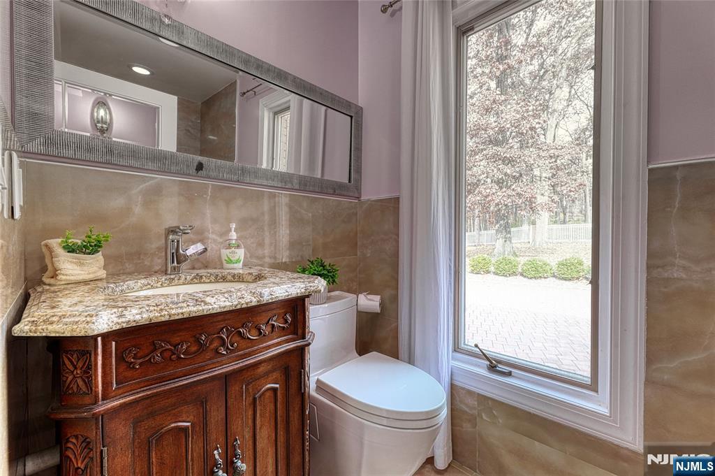 91 Chestnut Ridge Road Saddle River, NJ 07458 - Photo 27 of 50 a bathroom with a granite countertop toilet sink and mirror