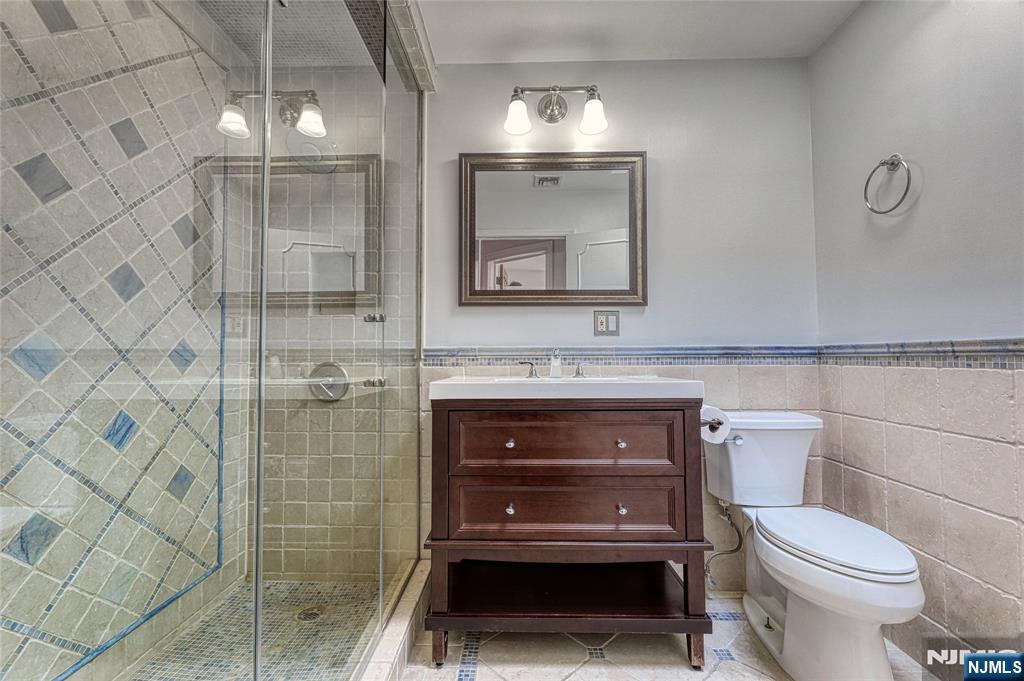91 Chestnut Ridge Road Saddle River, NJ 07458 - Photo 30 of 50 a bathroom with a toilet a sink and mirror