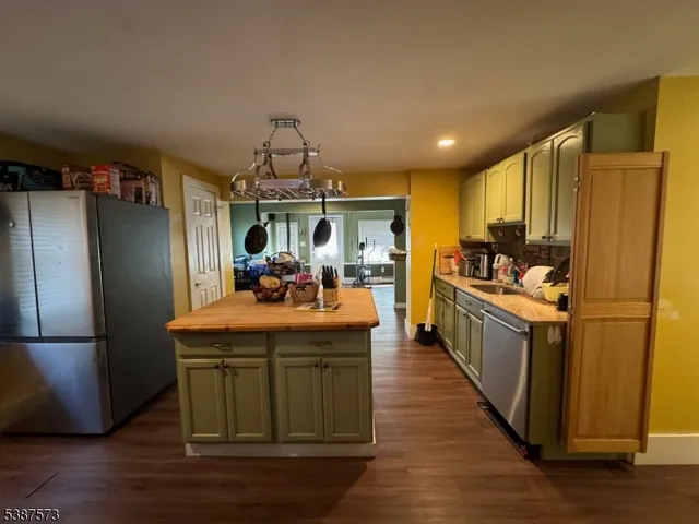 a kitchen with stainless steel appliances granite countertop a refrigerator a stove and a wooden floors