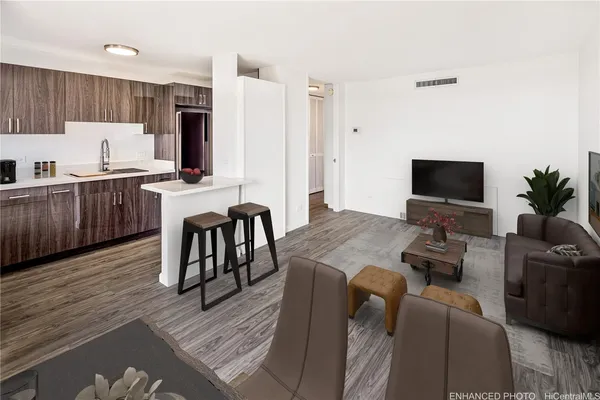 a living room with furniture a flat screen tv and kitchen view