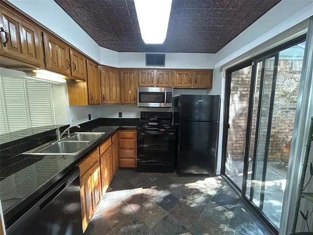 a kitchen with granite countertop a refrigerator and a sink