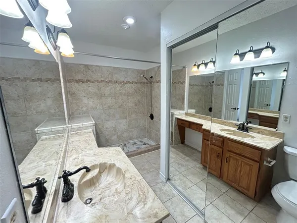 a bathroom with a double vanity sink mirror and shower