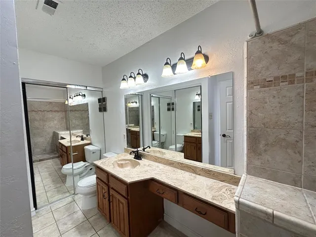 a bathroom with a double vanity sink toilet and shower