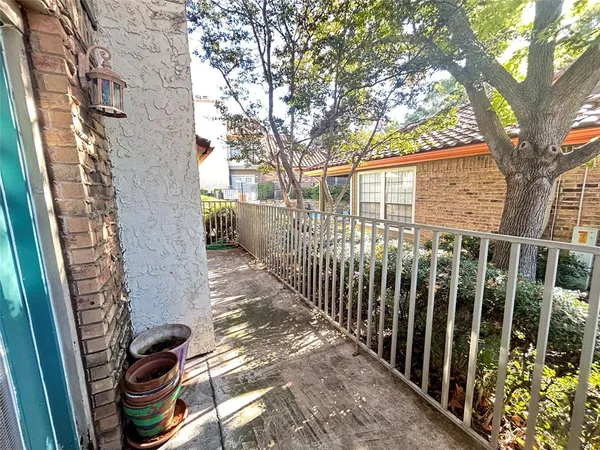 a view of a pathway of a house with a tree in the background