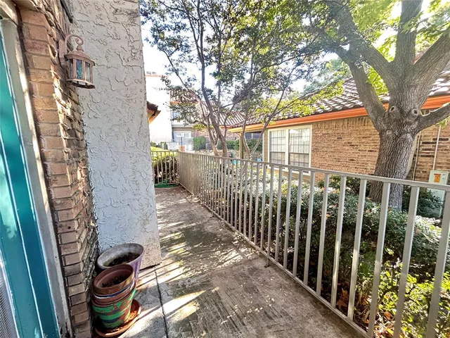 a view of a pathway of a house with a tree in the background