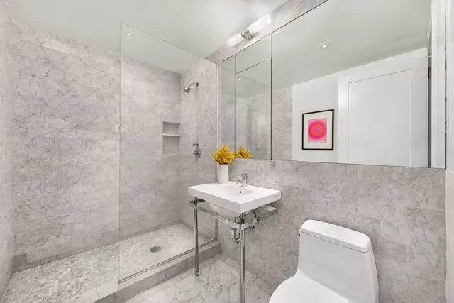 a bathroom with a sink a toilet and shower