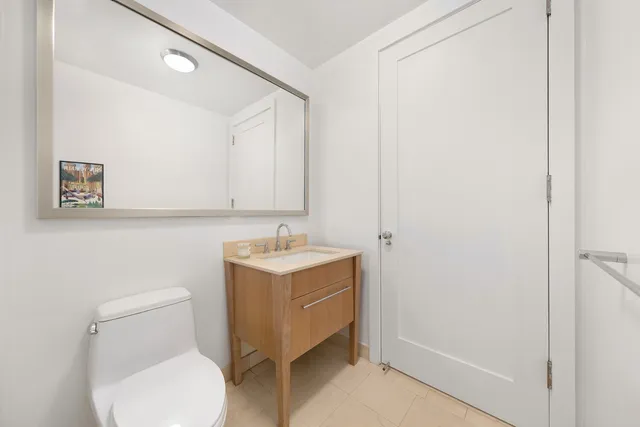 a bathroom with a toilet a sink and mirror