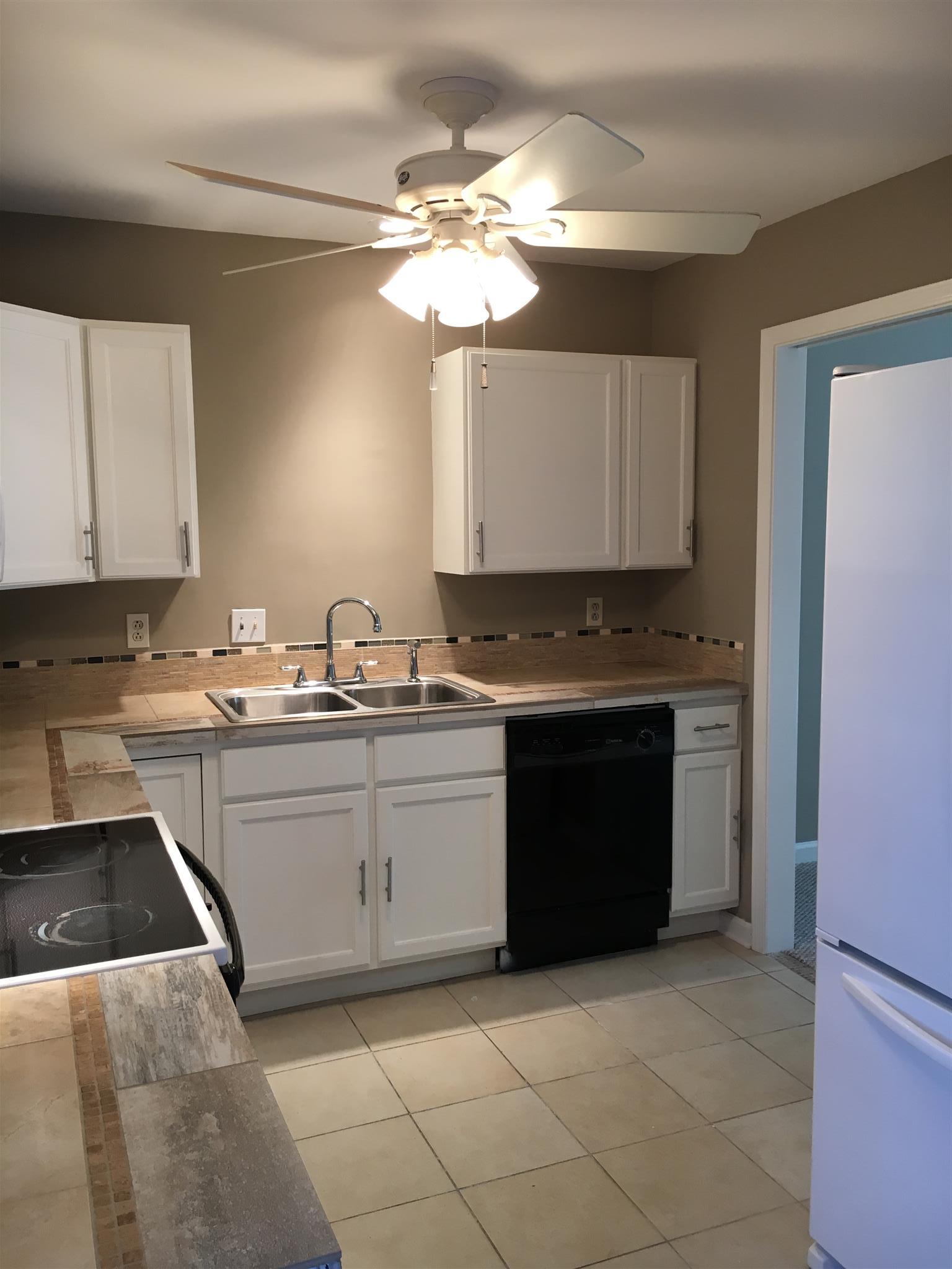1128 General George Patton Road, Unit 1128 Nashville, TN 37221 - Photo 8 of 26 a kitchen with stainless steel appliances granite countertop a stove sink and cabinets