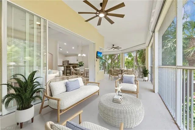 a living room with furniture and a large window with potted plants