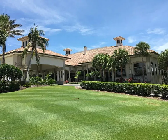 a view of a house with swimming pool lawn chairs and a dining table
