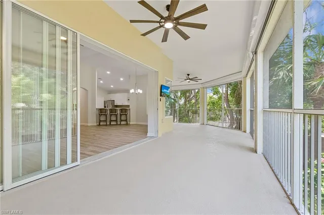 a view of a hallway with a ceiling fan and windows