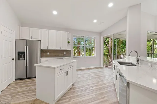 a kitchen with a sink a counter top space cabinets and stainless steel appliances