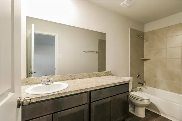 a bathroom with a granite countertop sink toilet and shower