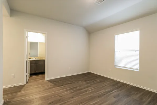 an empty room with wooden floor and a window