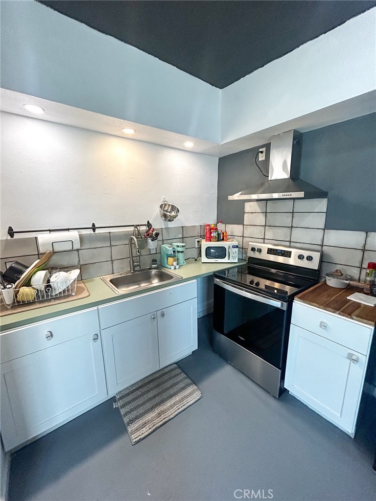 2139 Thomas Drive Blythe, CA 92225 - Photo 7 of 9 a kitchen with stainless steel appliances a stove and white cabinets