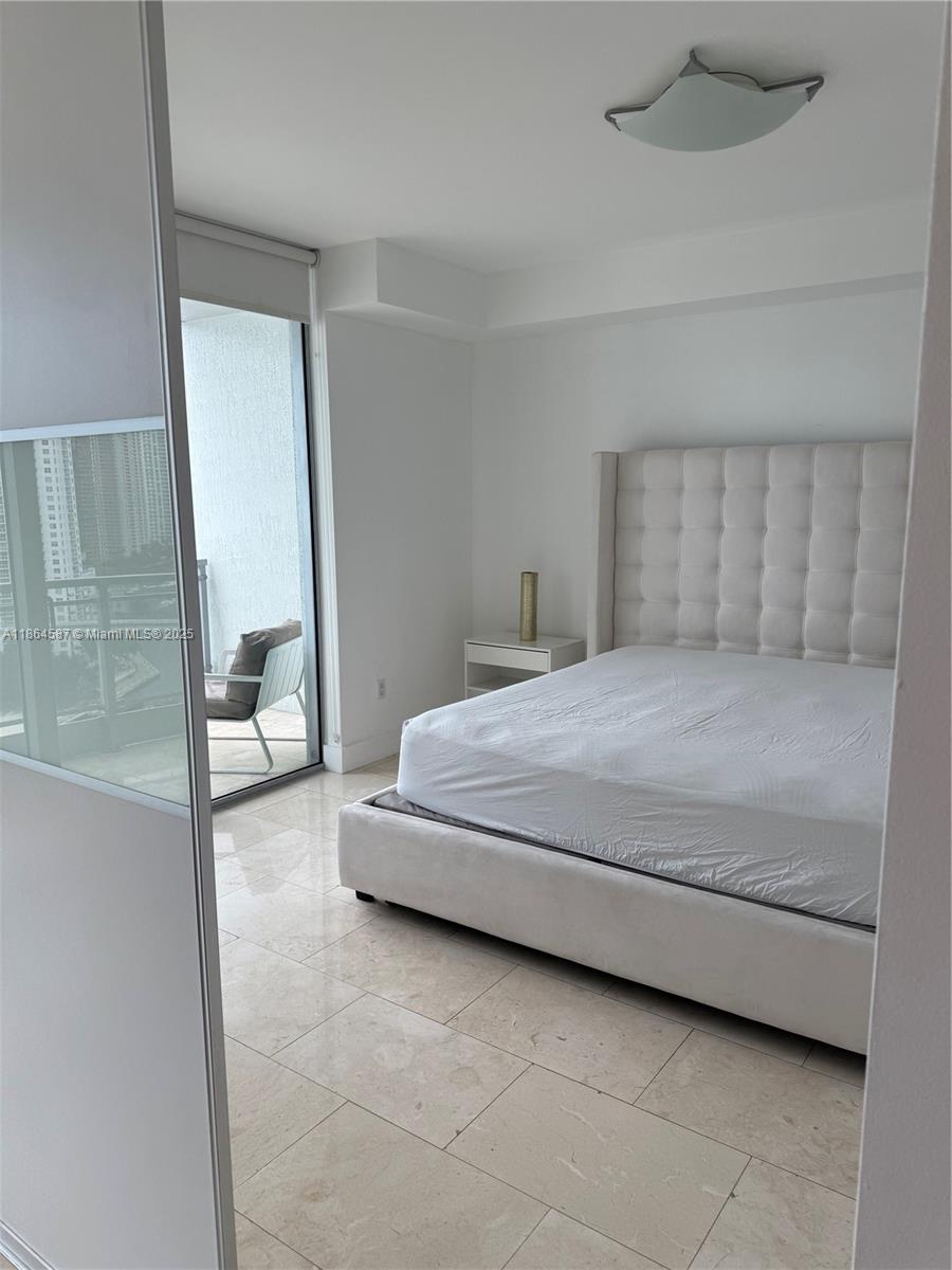 90 Southwest 3rd Street, Unit 2103 Miami, FL 33130 - Photo 14 of 31 a bedroom with a bed and a mirror
